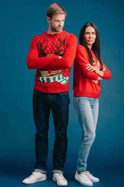 Upset Couple Christmas Sweaters Standing Crossed Arms Isolated Blue — Stock Photo, Image