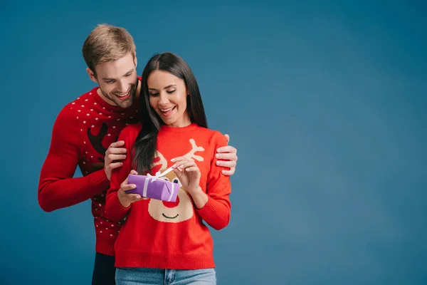 Cheerful Girlfriend Opening Christmas Present Boyfriend Isolated Blue — Stock Photo, Image