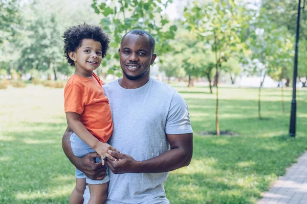 Leende Afrikansk Amerikansk Man Hålla Bedårande Son Och Titta Kameran — Stockfoto