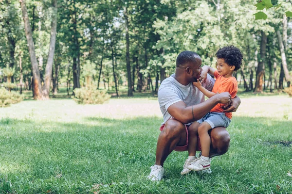 Χαριτωμένο Αφροαμερικανό Αγόρι Κάθεται Στα Γόνατα Του Ευτυχισμένου Πατέρα Στο — Φωτογραφία Αρχείου
