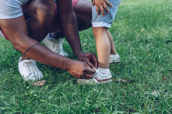 Ausgeschnittene Ansicht Eines Afroamerikaners Der Schnürsenkel Seines Sohnes Park Bindet — Stockfoto