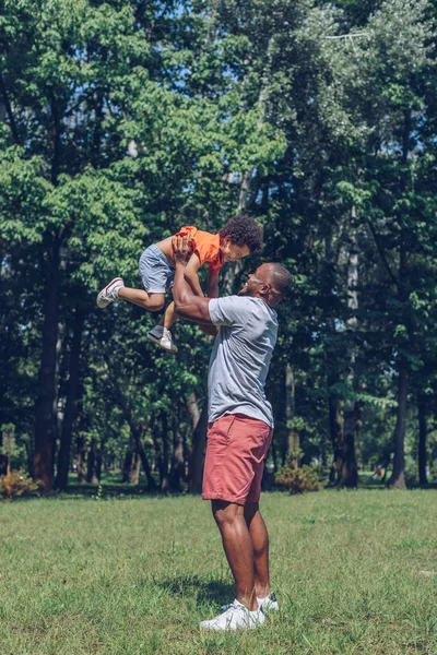 Gelukkig Afrikaans Amerikaanse Man Houden Vrolijk Zoon Boven Hoofd Terwijl — Stockfoto