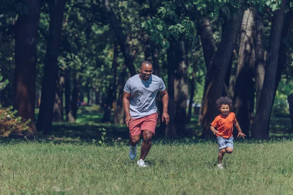 Χαρούμενος Αφρικάνος Πατέρας Και Γιος Τρέχουν Ενώ Διασκεδάζουν Στο Πάρκο — Φωτογραφία Αρχείου