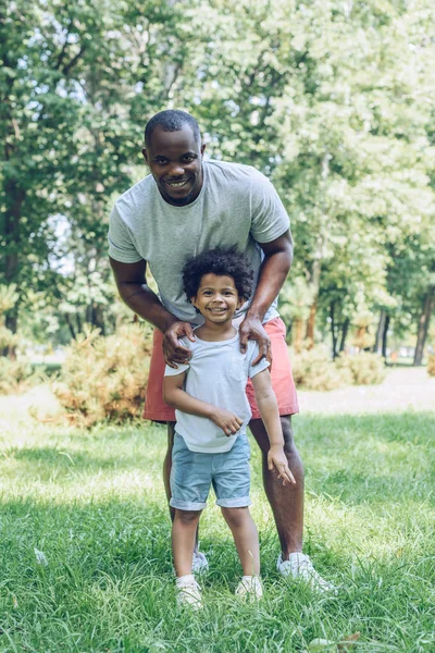 Feliz Afroamericano Padre Hijo Sonriendo Cámara Mientras Camina Parque — Foto de Stock