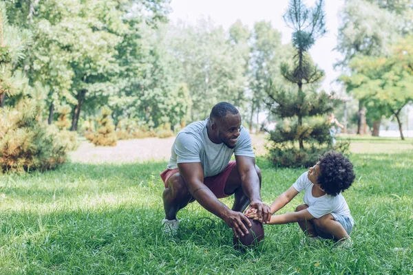 Smiling African American Man Showing Rugby Ball Adorable Son Park — Stock Photo, Image
