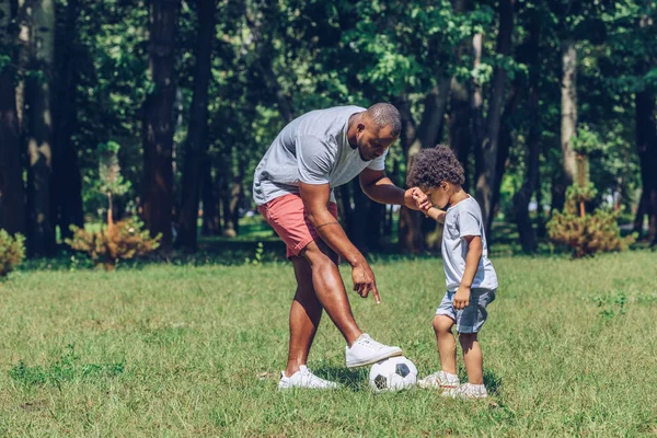 Young African American Man Teaching Adorable Son Playing Football Park — Stock Photo, Image