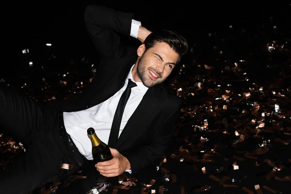 Elegante Uomo Con Bottiglia Champagne Sdraiato Sul Pavimento Con Confetti — Foto Stock