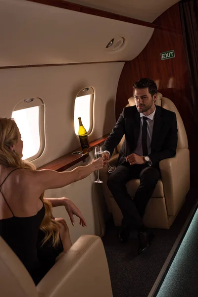 Módní Pár Cinkání Sklenicemi Šampaňského Při Cestování Letadle — Stock fotografie