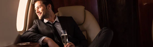 Красивый Веселый Мужчина Держит Бокал Шампанского Самолете — стоковое фото