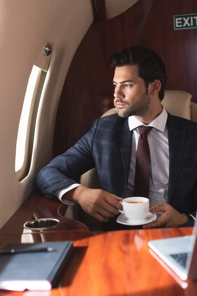 Homem Negócios Confiante Terno Segurando Xícara Café Avião Durante Viagem — Fotografia de Stock