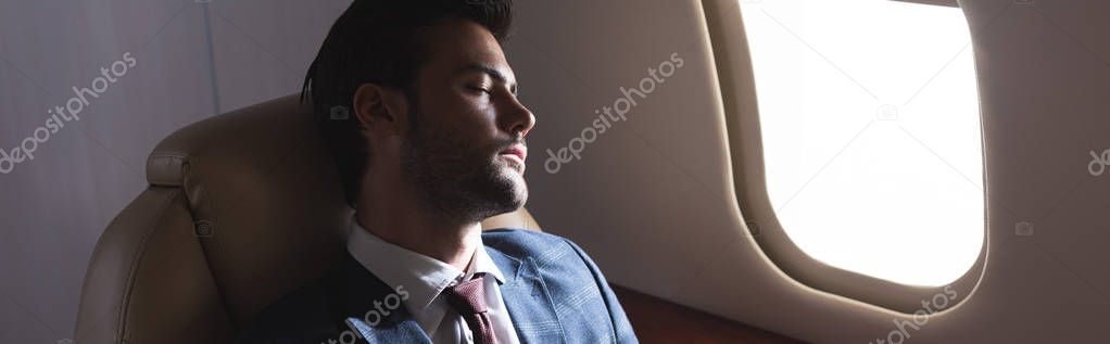 handsome businessman sleeping in plane during business trip