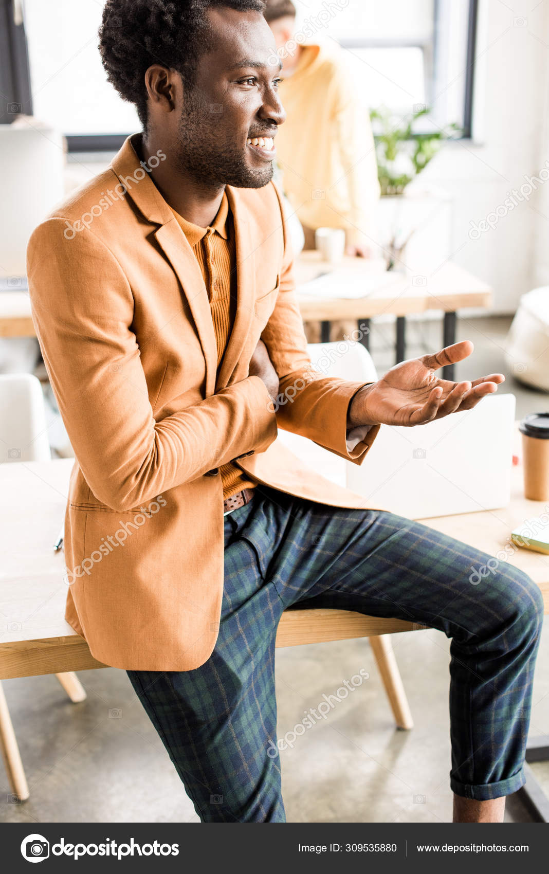 Bel Homme D'affaires Afro Américain Souriant Gestuel Assis Sur Bureau —  Photo de stock par ©VitalikRadko - 309535880, image size:1068x1700