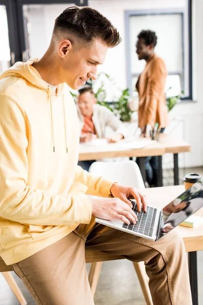 Młody Biznesmen Korzystający Laptopa Pobliżu Wielokulturowych Kolegów Pracujących Biurze — Zdjęcie stockowe