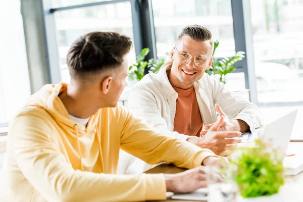 Dos Jóvenes Empresarios Conversando Sentados Juntos Lugar Trabajo — Foto de Stock