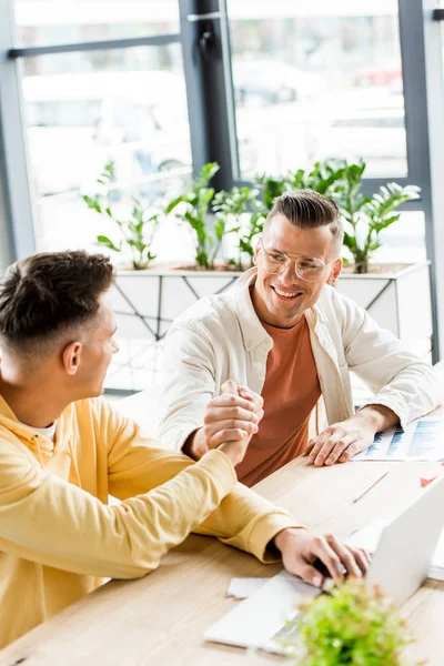 Dos Jóvenes Guapos Hombres Negocios Estrechando Mano Mientras Sientan Juntos — Foto de Stock