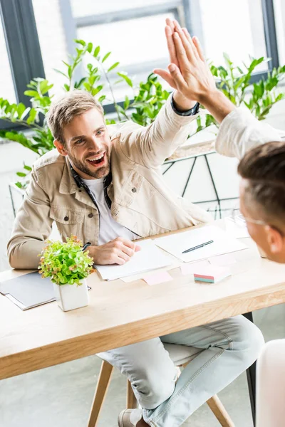 Jóvenes Hombres Negocios Guapos Dando Cinco Altos Mientras Está Sentado — Foto de Stock