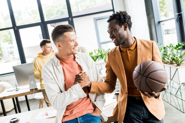 Sonriente Hombre Negocios Afroamericano Sosteniendo Voleibol Estrechando Mano Con Colega — Foto de Stock