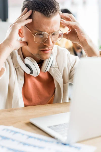 Young Pensive Businessman Looking Laptop While Sitting Headphones Neck — Stock Photo, Image