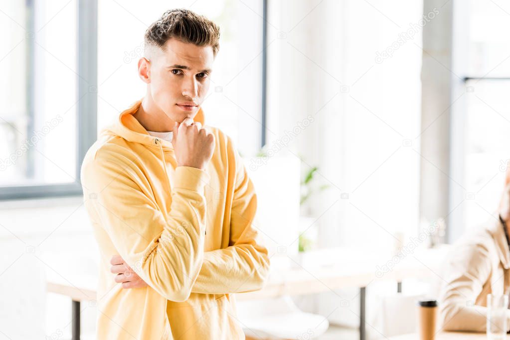 Handsome young businessman in casual clothing looking at camera