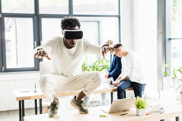 Afro Americano Uomo Affari Utilizzando Auricolare Accovacciato Sulla Scrivania Mentre — Foto Stock