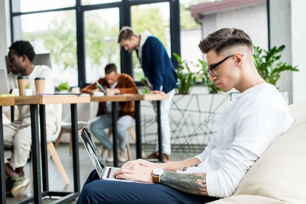 Joven Hombre Negocios Gafas Sentado Sillón Suave Uso Computadora Portátil — Foto de Stock