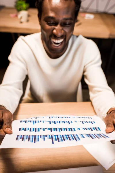 Foco Seletivo Empresário Afro Americano Feliz Segurando Papel Com Gráficos — Fotografia de Stock