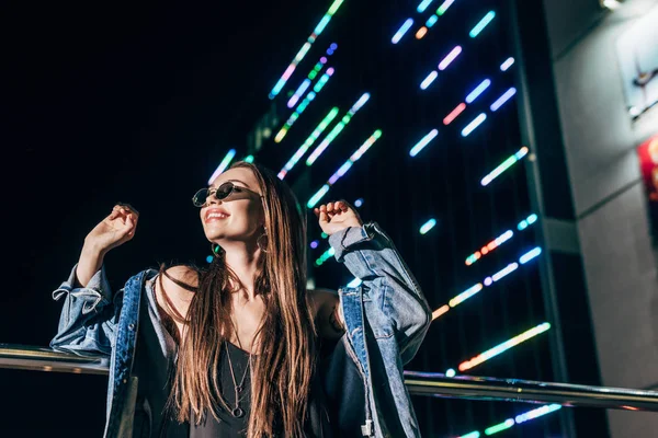 Mujer Atractiva Chaqueta Mezclilla Gafas Sol Sonriendo Mirando Hacia Otro —  Fotos de Stock