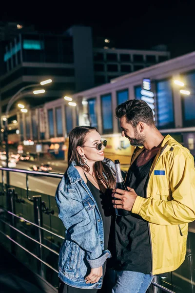 Aantrekkelijke Vriendin Knappe Vriendje Met Fles Glimlachen Naar Elkaar Kijken — Stockfoto