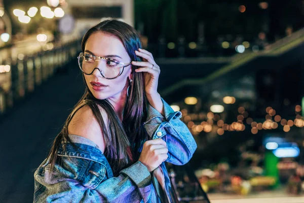 Attractive Woman Denim Jacket Glasses Looking Away Night City — Stock Photo, Image