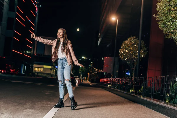 Attraktive Frau Rosa Jacke Trampt Und Lächelt Der Nacht Stadt — Stockfoto