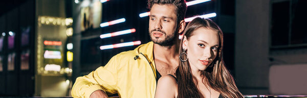 панорамный снимок красивого парня и привлекательной девушки в куртке в ночном городе
 