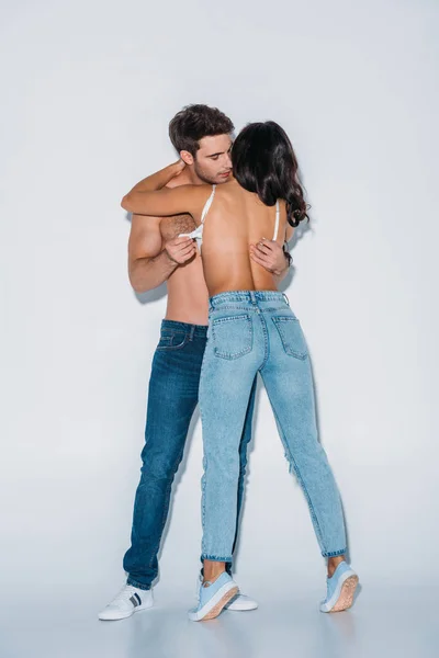 Stilig Man Tar Från Flicka Blå Jeans Grå Bakgrund — Stockfoto