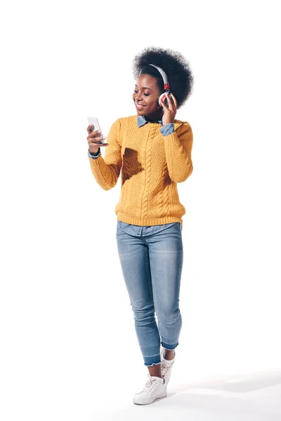 Uśmiechnięta Afroamerykanka Używająca Smartfona Słuchawkami Odizolowana Biało — Zdjęcie stockowe