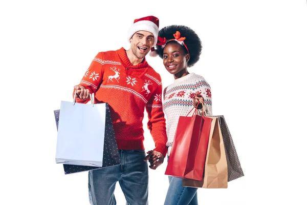 Pareja Multicultural Sombrero Santa Cuernos Ciervo Sosteniendo Bolsas Compras Aislado — Foto de Stock