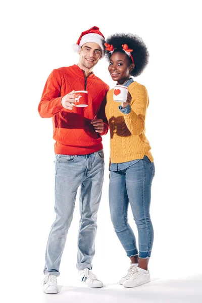 Multicultural Couple Santa Hat Deer Horns Drinking Coffee Together Isolated — Stock Photo, Image