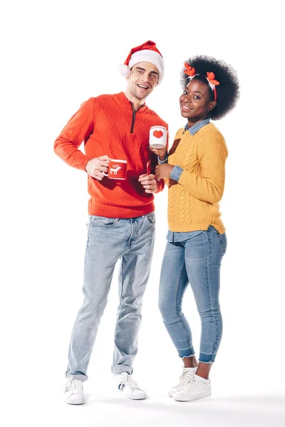 Multicultural Couple Santa Hat Deer Horns Drinking Coffee Together Isolated — Stock Photo, Image