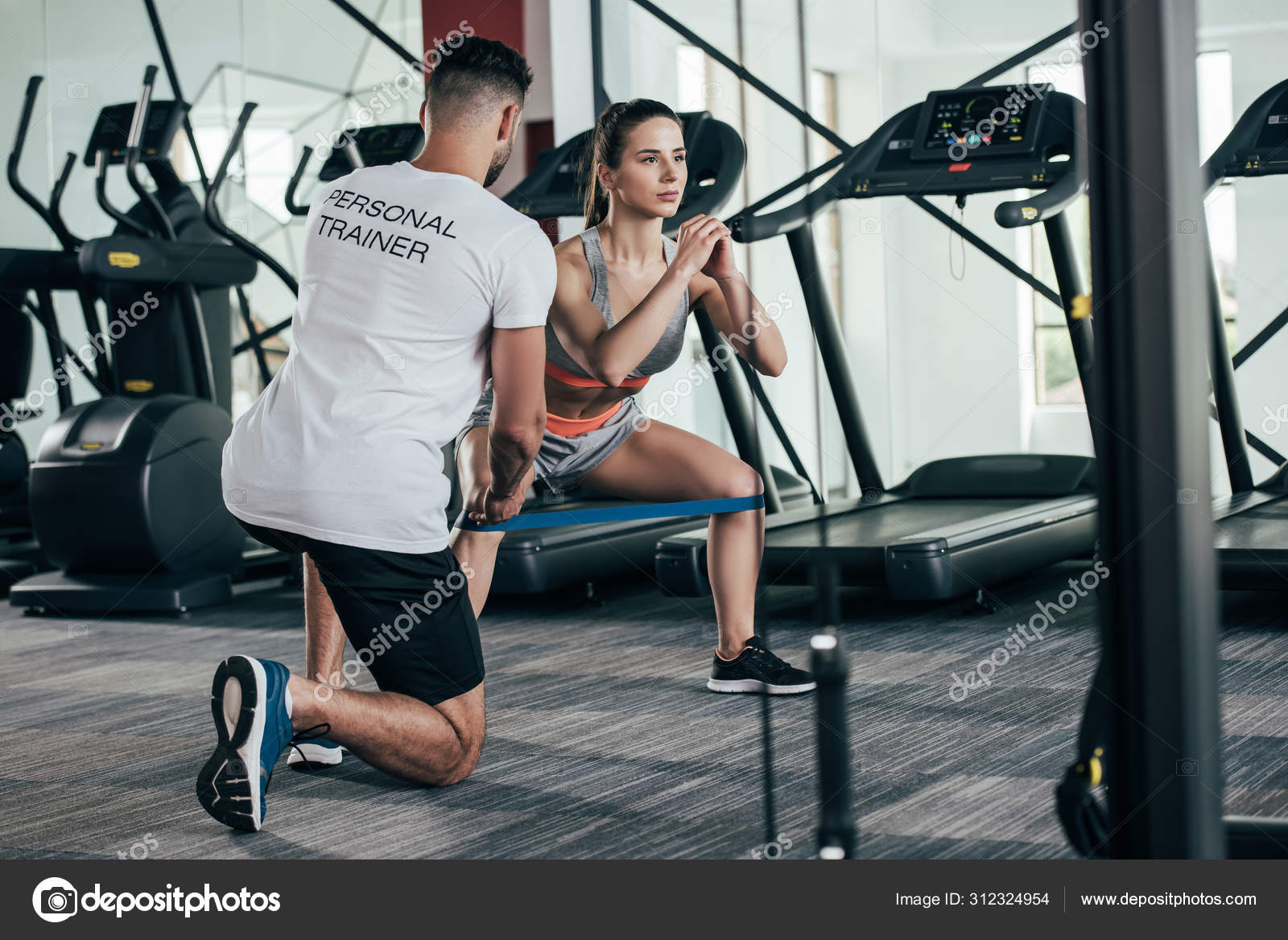 Back View Personal Trainer Supervising Young Sportswoman Exercising