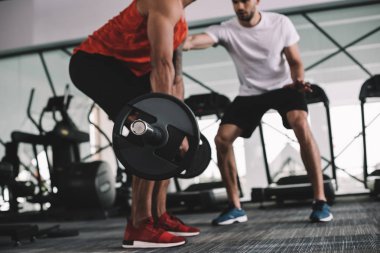 Amerikan sporcusunu destekleyen, halter kaldıran antrenör görüşü.
