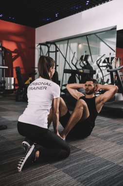 Genç antrenör yakışıklı sporcunun şınav çekmesini denetliyor.