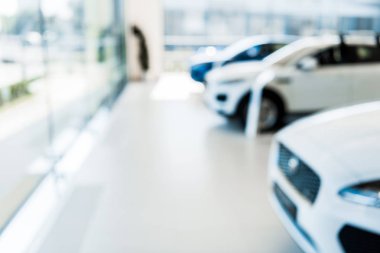 blurred car showroom with new and shiny cars  clipart