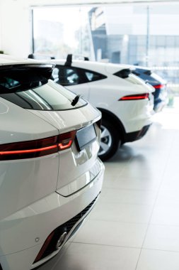 selective focus of white cars in car showroom  clipart