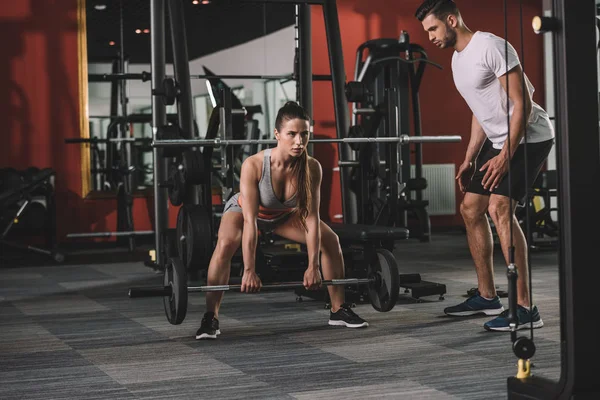 Bonito Treinador Supervisionando Atraente Desportista Levantando Barbell — Fotografia de Stock