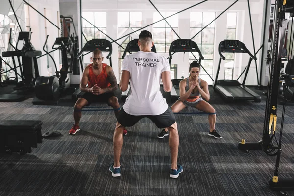 Vista Posterior Del Entrenador Personal Supervisando Atletas Multiculturales Calentándose Gimnasio — Foto de Stock