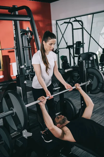 Aufmerksame Trainerin Unterstützt Sportler Beim Hantelheben Fitnessstudio — Stockfoto