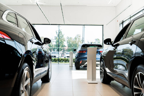 selective focus of black luxury cars in car showroom 