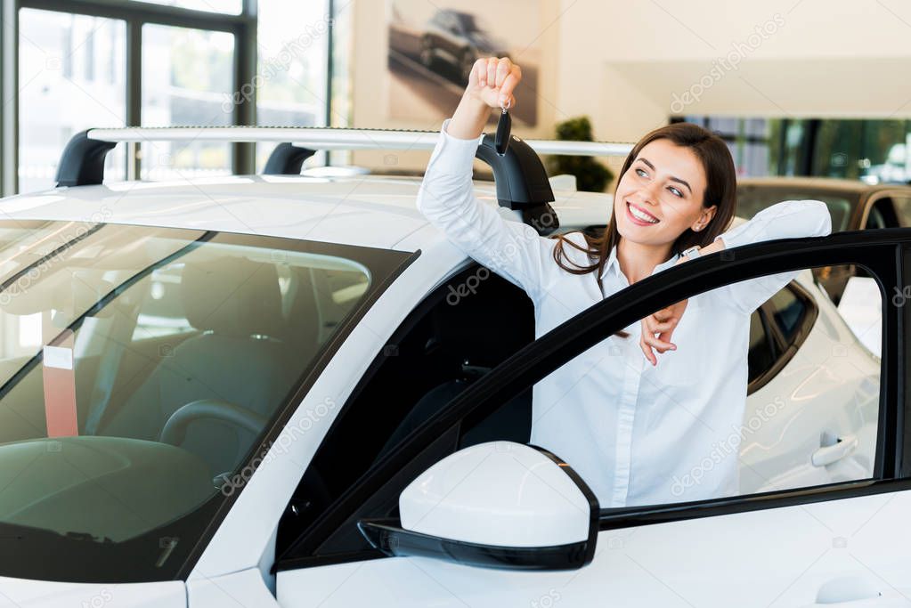 selective focus of positive young woman holding car key  