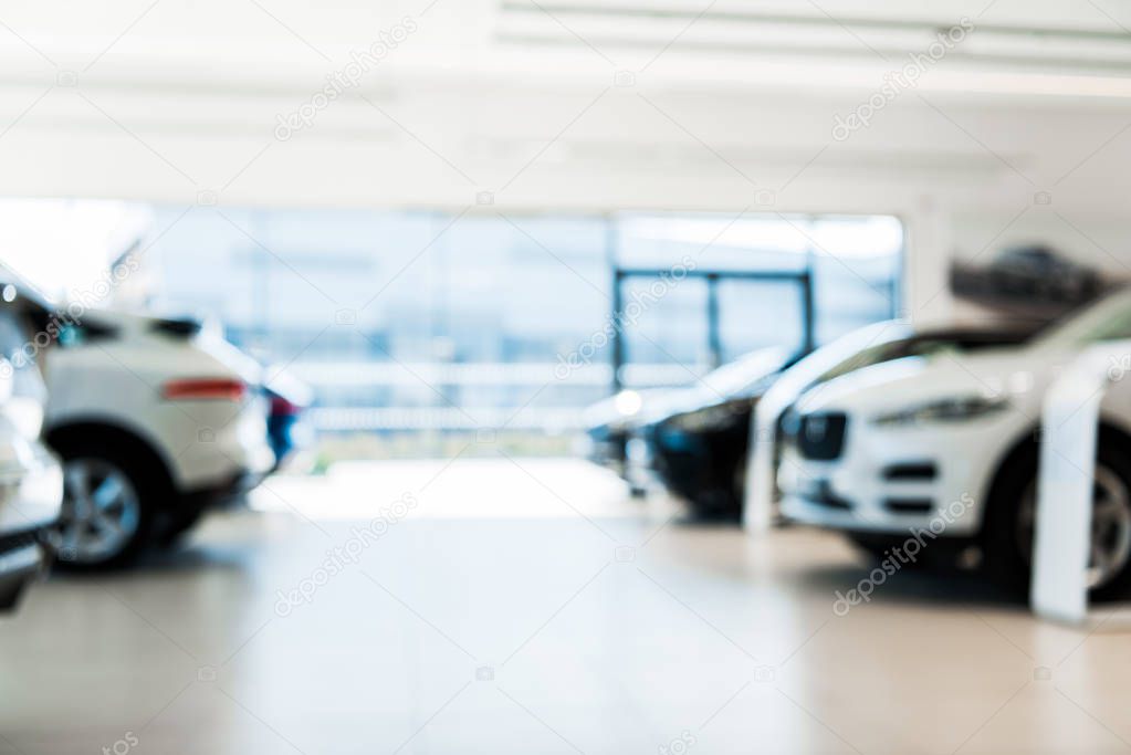 blurred car showroom with new and luxury cars 