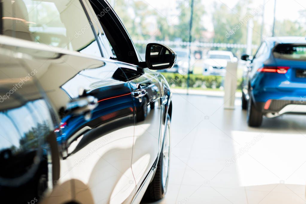 selective focus of blank and blue shiny cars in car showroom 