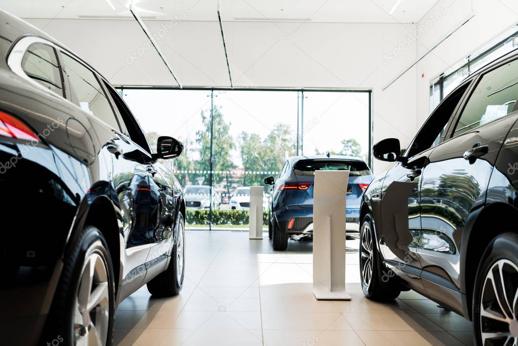 selective focus of black luxury cars in car showroom 