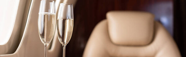 panoramic shot of champagne glasses in private jet 